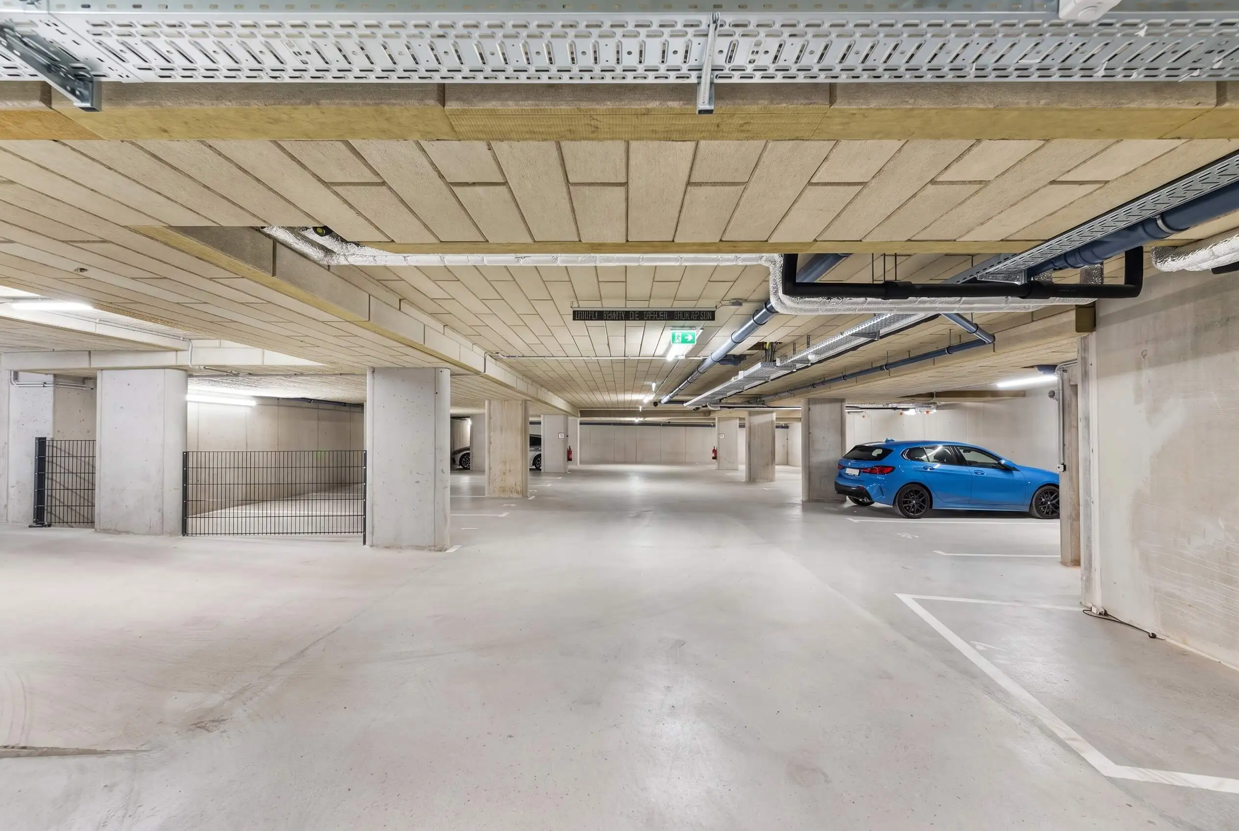 Blick auf helle, klar markierte Stellplätze einer KOUP-Wohnhausanlage